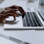 Quais são as vantagens de se ter um email profissional 3 Pessoa digitando em um laptop, simbolizando a comunicação eficaz através de um e-mail profissional
