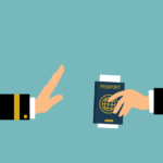 O Visto Foi Recusado. Imagem de duas mãos segurando um passaporte e um livro de passaporte, refletindo a frustração de um visto recusado