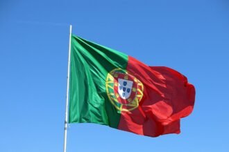 Portugal cancela agendamentos para visto de procura de trabalho, representado por uma bandeira