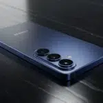 Uma fotografia detalhada e realista do Samsung Galaxy S26 Plus repousando sobre uma superfície de obsidiana escura, destacando sua moldura de titânio e o conjunto de câmeras triplas sob iluminação cinematográfica.