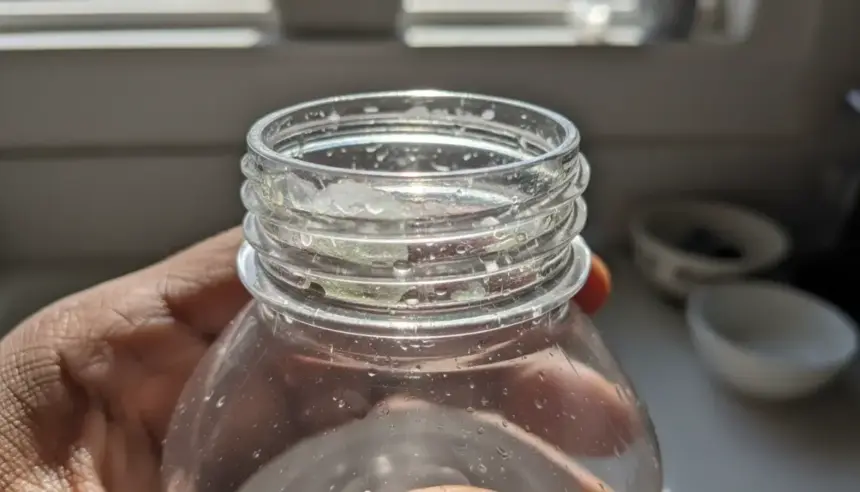 Biofilme garrafa água acumulado no interior e bocal de uma garrafa reutilizável com micro-organismos e lodo invisível.