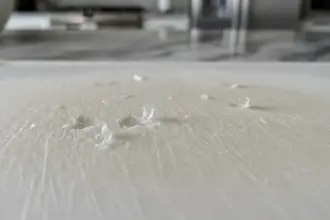 Tábua de corte sintética com ranhuras de uso. Pare de usar tábuas de plástico para evitar a ingestão de microplásticos.