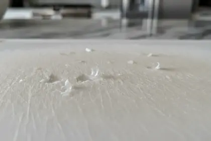 Tábua de corte sintética com ranhuras de uso. Pare de usar tábuas de plástico para evitar a ingestão de microplásticos.