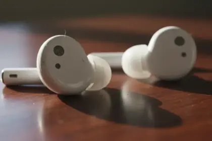 Fones de ouvido com acúmulo de bactérias, mostrando o perigo de earbuds sujos para os ouvidos e riscos à saúde.